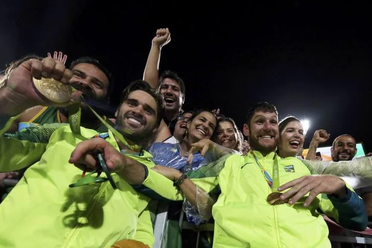 Bruno Schmidt e Alison comemoram a medalha de ouro do Brasil no vôlei de praia, na Arena de Copacabana (REUTERS/Adrees Latif)