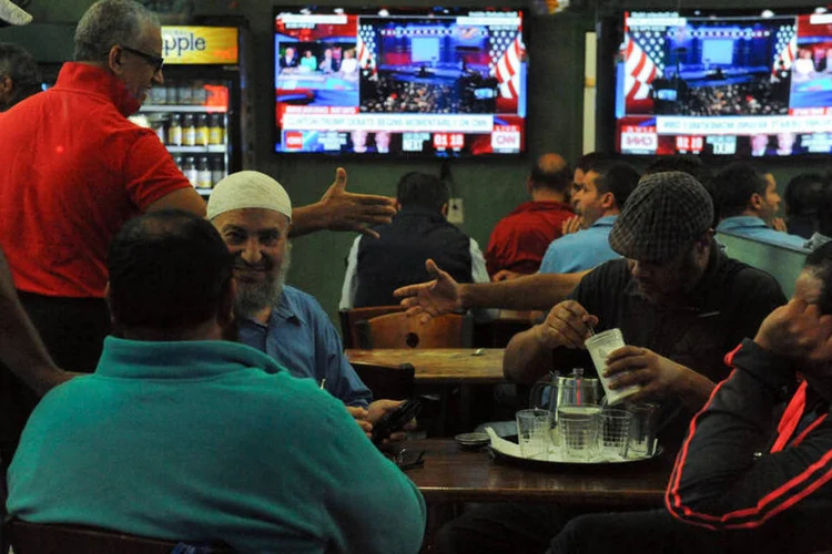 Festa da democracia: grupo de amigos acompanha o primeiro debate presidencial em um bar de Nova York (REUTERS/Stephanie Keith)
