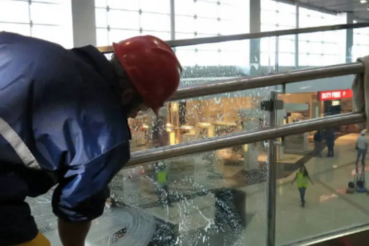 
	Funcion&aacute;rio limpa vidro de rampa que d&aacute; acesso ao &uacute;ltimo andar do terminal, onde ficam as Salas VIPs do terminal 3 do Aeroporto de Guarulhos
 (Marina Pinhoni/EXAME.com)