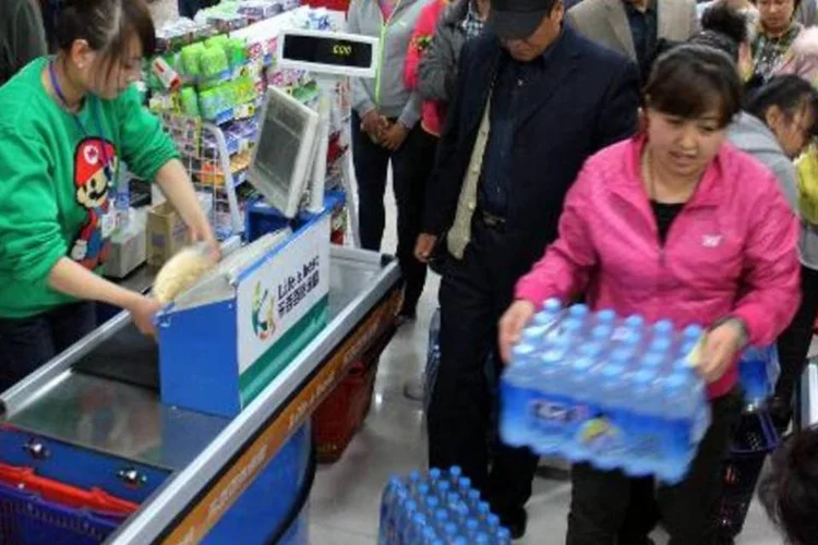 Habitantes de Lanzhou correm aos supermercados para comprar água mineral depois da notícia do vazamento de petróleo no sistema de água local (AFP)