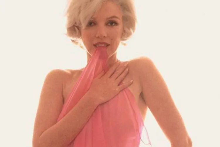 
	Marilyn Monroe: num quarto de hotel, a atriz agarrou um len&ccedil;ol de seda transparente, olhou atrav&eacute;s da tela e perguntou se Stern gostaria de fazer fotos nuas
 (Bert Stern/Divulgação)