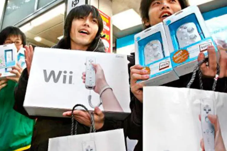 
	Japoneses exibem o &quot;novo&quot; console Wii no lan&ccedil;amento em dezembro de 2006: lan&ccedil;ado h&aacute; sete anos no Jap&atilde;o, o Wii vendeu mais de 100 milh&otilde;es de exemplares no mundo
 (YOSHIKAZU TSUNO/AFP)
