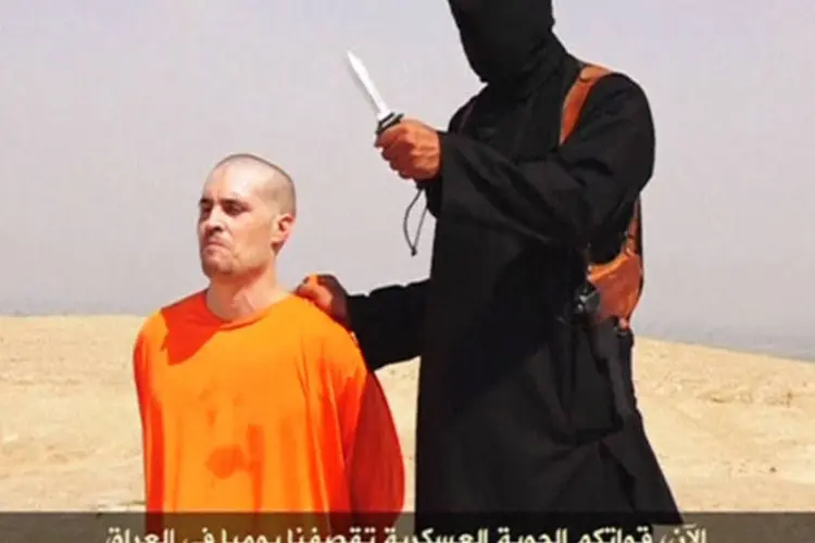 
	Militante do EI segura faca pr&oacute;ximo ao jornalista James Foley, que foi decapitado
 (REUTERS/Social Media Website via REUTERS TV)