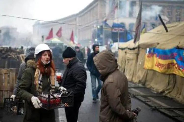 Mulher oferece sopa a manifestantes da oposição na Praça da Independência de Kiev, no dia 8 de fevereiro (Afp.com / Martin Bureau)