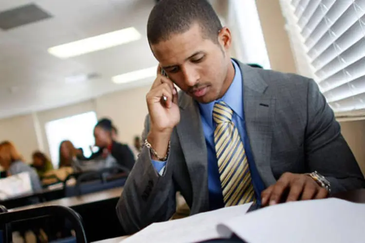 Homem falando ao telefone e lendo (Getty Images)