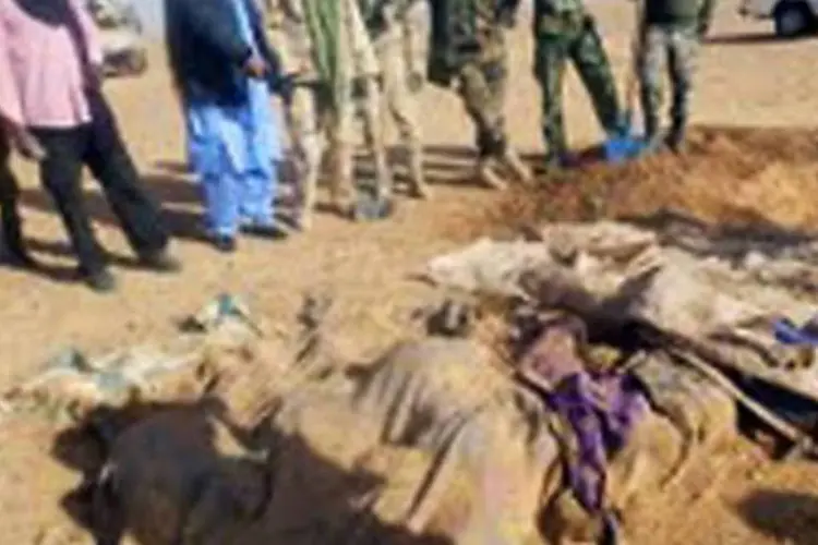 Um fotografia feita com celular mostra soldados observando os corpos de alguns dos 92 nigerinos que morreram de sede no deserto, perto da fronteira com a Argélia (Reprodução/AFP)