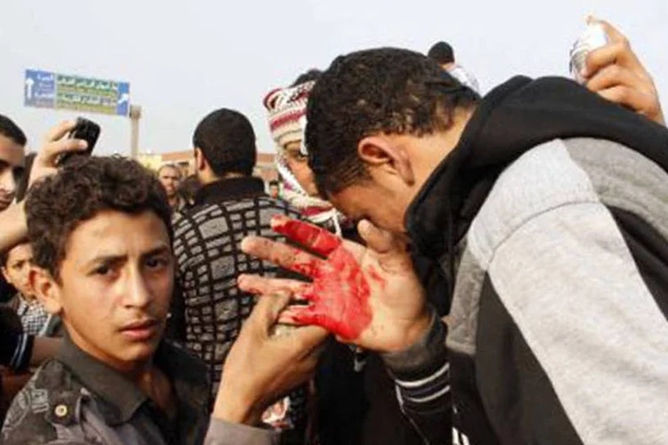 Simpatizante da Irmandade Muçulmana é ferido após ser atingido com pedras do ladod e fora de uma seção eleitoral em Giza, 14 de janeiro de 2014
 (Khaled Kamel/AFP)