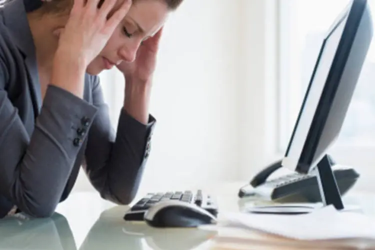 Mulher com dor de cabeça usando o computador (Getty Images)