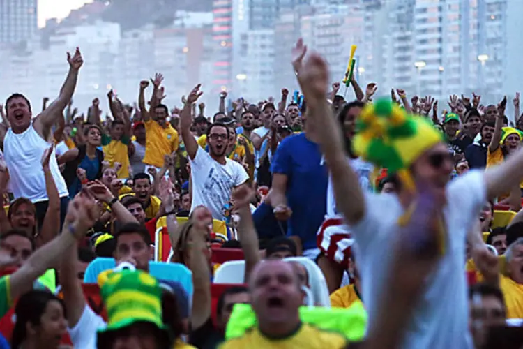 Torcida: pessoas assistindo aos jogos com sinal analógico comemoram o gol antes (Mario Tama/Getty Images)