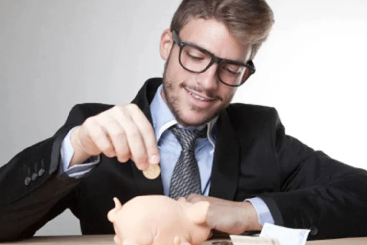 
	Jovem p&otilde;e dinheiro em cofrinho: palestras s&atilde;o voltadas para quem quer entender certos investimentos e organizar melhor as finan&ccedil;as
 (Getty Images)
