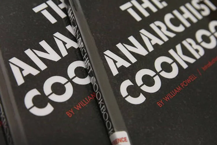 
	C&oacute;pias do livro &quot;The Anarchist Cookbook&quot;, de William Powell: a publica&ccedil;&atilde;o &eacute; um manual sobre como produzir drogas, t&eacute;cnicas de contravigil&acirc;ncia e fabrica&ccedil;&atilde;o de explosivos
 (Scott Olson/Getty Images)