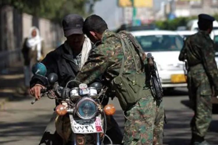 Soldado iemenita revista motociclista em posto de controle da capital Sanaa em 23 de novembro (Mohammed Huwais/AFP)