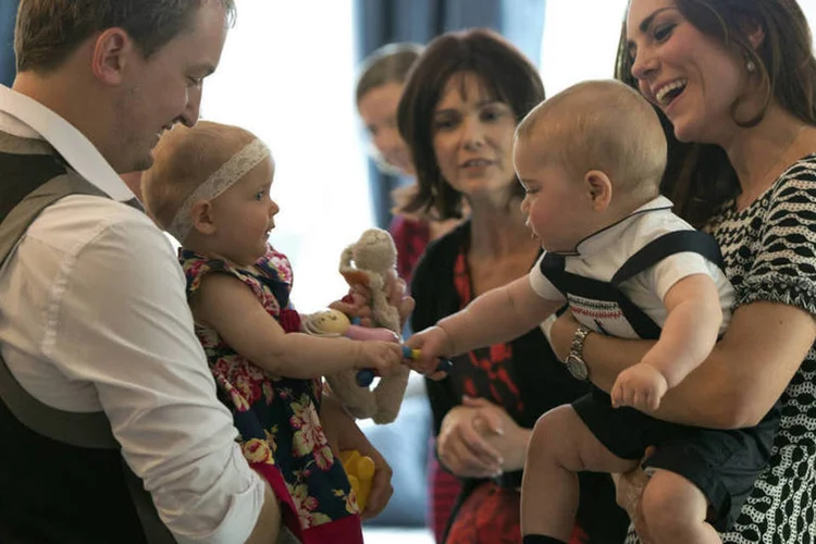 
	No colo da m&atilde;e Kate, o pr&iacute;ncipe George brinca com beb&ecirc; durante encontro oficial na Nova Zel&acirc;ndia:&nbsp;fam&iacute;lia real brit&acirc;nica chegou ontem na Austr&aacute;lia
 (Government House NZ via Getty Images)
