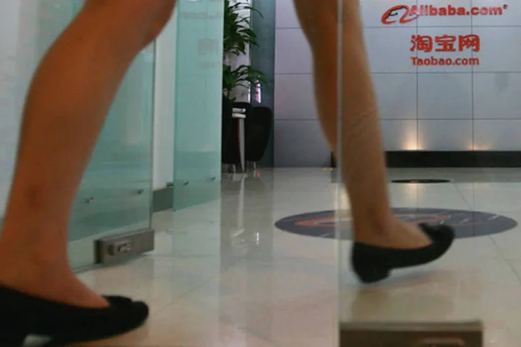 
	Mulher entra no pr&eacute;dio da Alibaba, na China, em Pequim: junto com a Weibo, companhia deve trabalhar na conectividade de conta, troca de dados, pagamentos e marketing online
 (Guang Niu/Getty Images)
