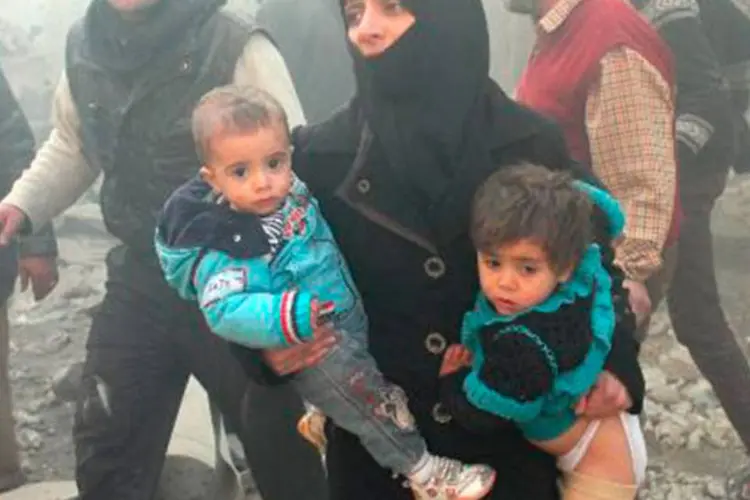 
	Mulher s&iacute;ria carrega os filhos para fugir das bombas em Aleppo: segundo a ONU, mais de 100.000 pessoas morreram na S&iacute;ria desde o in&iacute;cio do conflito
 (Mohammed Al-Khatieb/AFP)