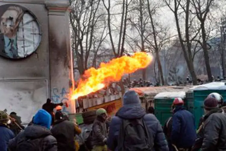 
	Manifestante joga fogo em dire&ccedil;&atilde;o &agrave; pol&iacute;cia durante confrontos em Kiev, na Ucr&acirc;nia: v&aacute;rias pessoas j&aacute; ficaram feridas
 (Sergei Supinsky/AFP)