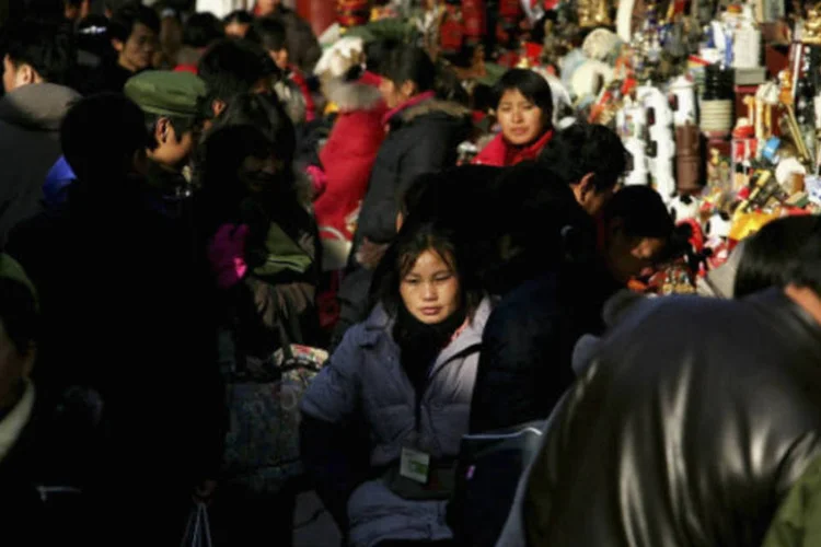 Pessoas caminham por rua de comércio em Pequim, na China (Guang Niu/Getty Images)
