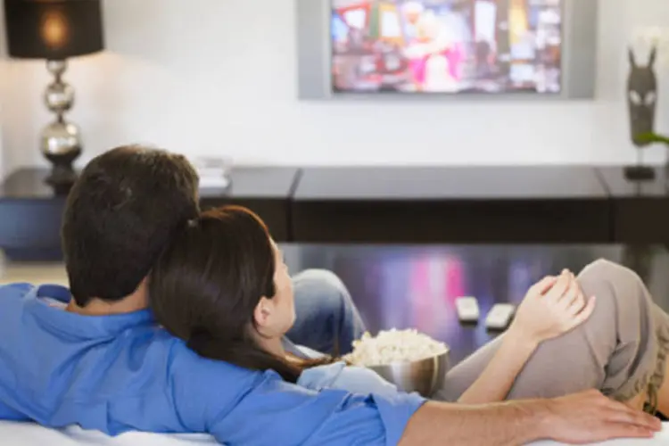 
	Casal assiste televis&atilde;o: em uma d&eacute;cada, o mercado de TV por assinatura cresceu mais de 330%
 (Getty Images)