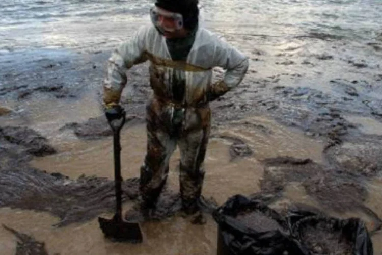 
	Um volunt&aacute;rio descansa da sua atividade de retirar &oacute;leo que vazou do petroleiro Prestige: Prestige afundou na costa noroeste da Espanha, causando um desastre ambiental
 (AFP)