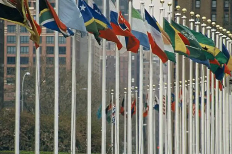 
	Bandeiras de pa&iacute;ses em frente de pr&eacute;dio da ONU: voto negativo de membro permanente configura veto a uma eventual resolu&ccedil;&atilde;o do conselho, o que eleva a import&acirc;ncia do assento permanente
 (Aotearoa / Wikimedia Commons)