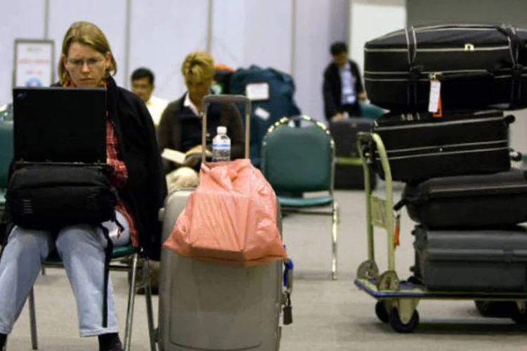 
	Passageira utiliza computador em aeroporto: as cidades sede da Copa das Copa das Confedera&ccedil;&otilde;es de 2013 e a Copa do Mundo de 2014 ter&atilde;o banda larga nos terminais
 (Paula Bronstein/Getty Images)