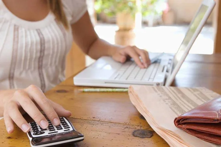 Empreendedora com calculadora (Thinkstock)