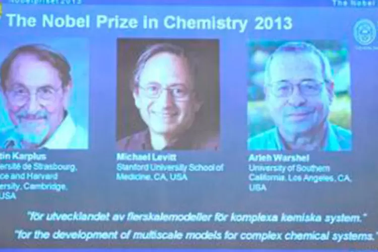 Da esquerda para a direita, fotos de Martin Karplus, Michael Levitt e Arieh Warshel são projetadas durante anúncio do Prêmio Nobel de Química
 (JONATHAN NACKSTRAND/AFP)