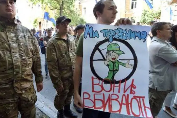 
	Homem exibe cartaz com a frase &quot;n&oacute;s conversamos - eles matam&quot;&nbsp;
 (Sergei Supinsky/AFP)