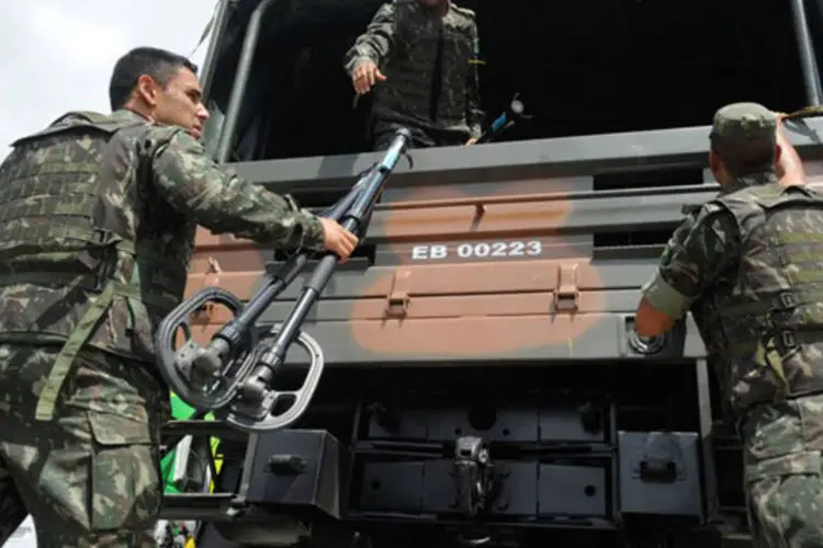 Militares do 1º Batalhão de Engenharia de Combate-Escola do Exército aguardam para entrar no Complexo da Maré,em uma operação de buscas a armamentos enterrados por traficantes (Tânia Rêgo/Agência Brasil)