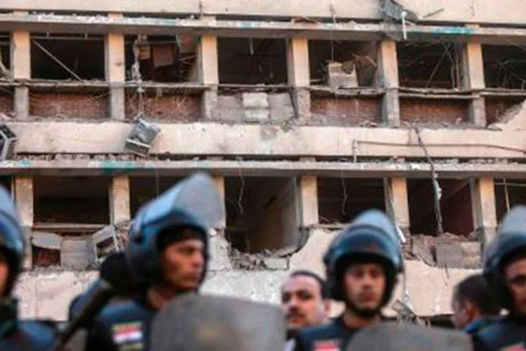 
	Policiais s&atilde;o vistos diante de fachada danificada de centro policial no Cairo, no Egito: a explos&atilde;o tamb&eacute;m causou v&aacute;rios danos materiais
 (Mahmoud Khaled;AFP)