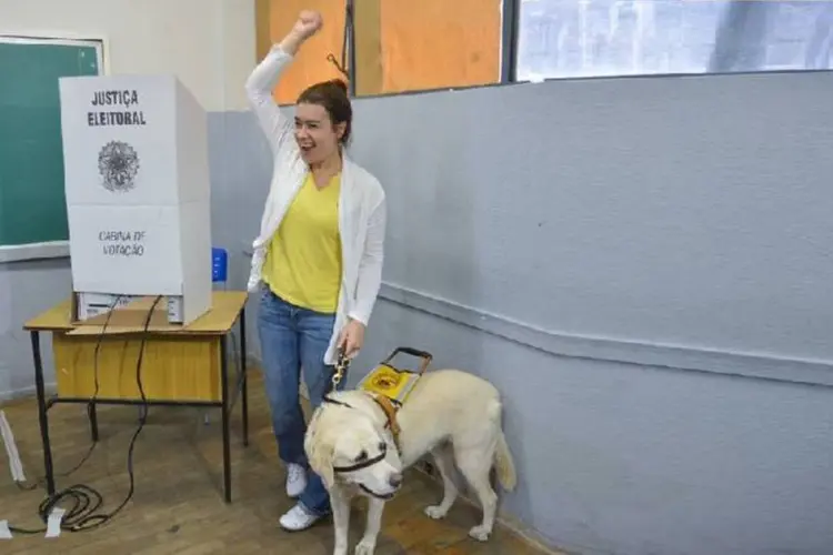 Eleitora com deficiência visual vota com cão guia (Valter Campanato/Agência Brasil)