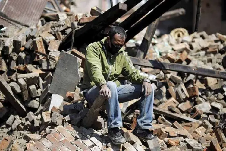 
	Um homem senta-se sobre os escombros de sua casa danificada ap&oacute;s o terremoto de s&aacute;bado, em Bhaktapur, Nepal
 (REUTERS)