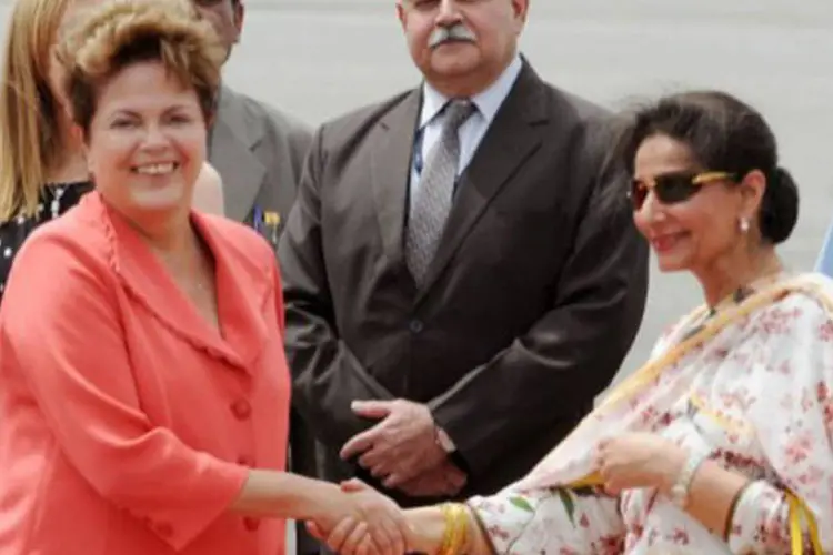 A presidente do Brasil, Dilma Rousseff (e), é recebida pela ministra indiana para Assuntos Externos, Preneet Kaur: Dilma foi a primeira a chegar em Nova Délhi (Hansraj/AFP)