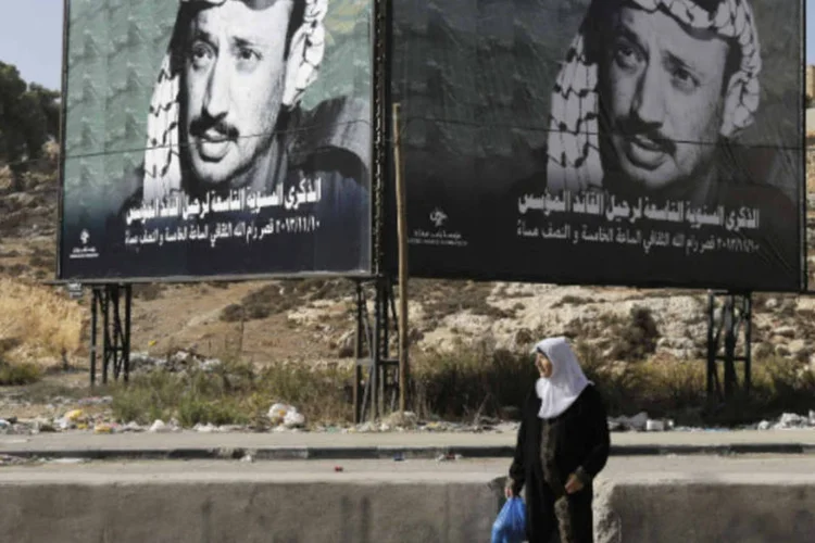 
	Mulher em frente a um oudoor com imagens do l&iacute;der palestino Yasser Arafat: declara&ccedil;&atilde;o de 88 deu o tiro de largada a um intermin&aacute;vel processo de paz
 (Reuters/Ammar Awad)