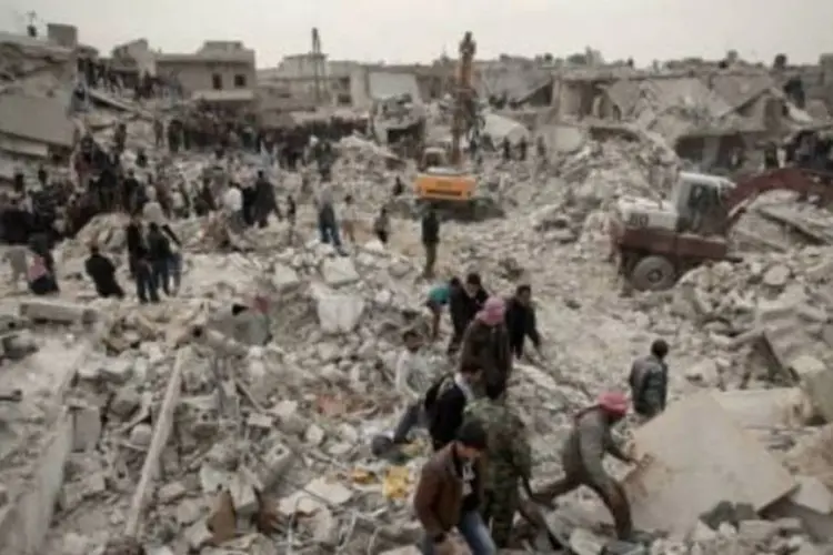 Sírios procuram sobreviventes e corpos no meio dos escombros de edifícios no distrito de Tariq al-Bab, em Aleppo, em 23 de fevereiro de 2013. (AFP)
