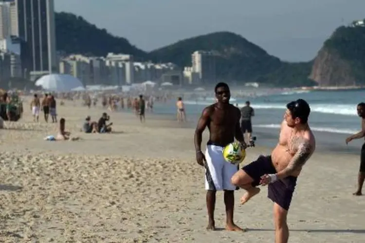 
	Homens jogam futebol em Copacabana: alguns brasileiros v&atilde;o torcer contra
 (AFP)