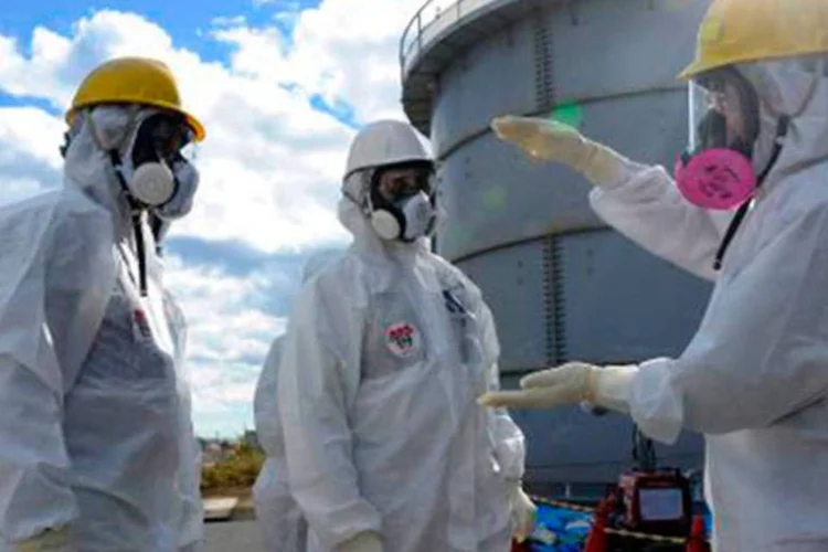 
	Especialistas ao lado da central nuclear de Fukushima: trata-se da sexta vez que a Tepco solicita fundos ao Estado
 (Tepco/AFP)