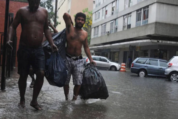 
	Pessoas passam por rua alagada no Rio: em praticamente todos os bairros h&aacute; bols&otilde;es d&#39;&aacute;gua
 (Tomaz Silva/Agência Brasil)
