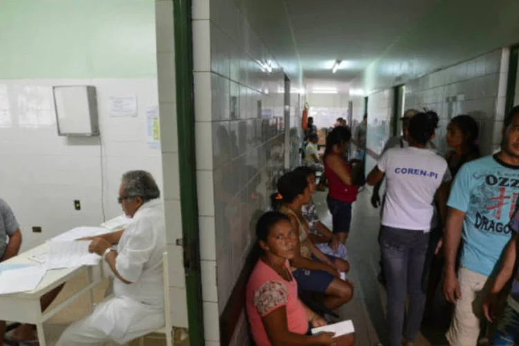 
	M&eacute;dico atende pacientes, enquanto outros esperam: durante essas tr&ecirc;s semanas, os m&eacute;dicos participa&ccedil;&atilde;o de aulas expositivas, oficinas e simula&ccedil;&atilde;o de consultas e de casos complexos.
 (Agência Brasil)