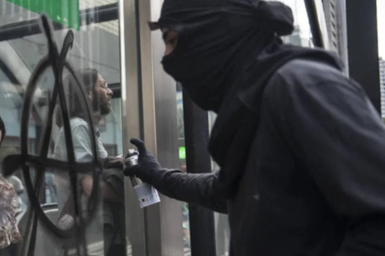 
	Manifestante do Black Bloc picha muro com o s&iacute;mbolo anarquista durante protestos do 7 de Setembro
 (Marcelo Camargo/ABr)
