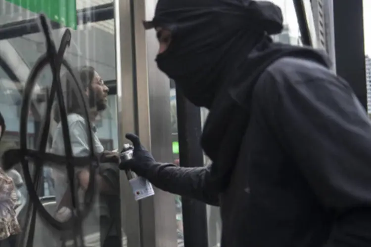 
	Manifestante do Black Bloc picha muro com o s&iacute;mbolo anarquista: grupo &eacute; acudado&nbsp;de incitar e cometer atos de vandalismo
 (Marcelo Camargo/ABr)