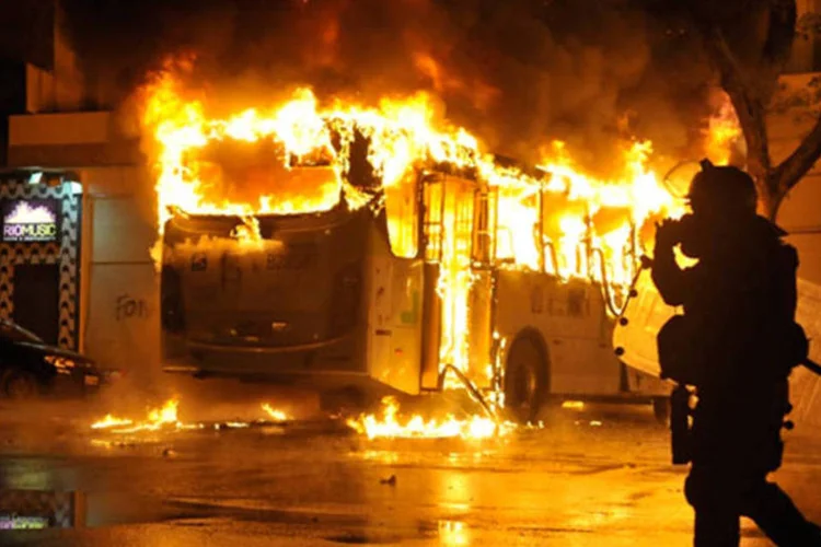 
	Policial observa &ocirc;nibus incendiado em protesto:&nbsp;manifestantes colocaram fogo em tr&ecirc;s &ocirc;nibus e saquearam um minimercado
 (Fernando Frazão/ABr)