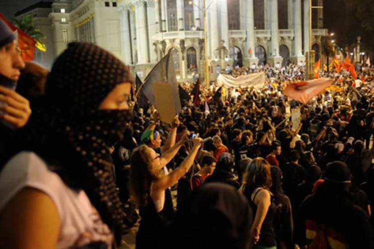 
	Grupos de mascarados que apoiavam o protesto entraram em confronto com PMs na Cinel&acirc;ndia: segundo zelador da C&acirc;mara, os manifestantes tentaram atear fogo nas janelas
 (Fernando Frazão / Agência Brasil)