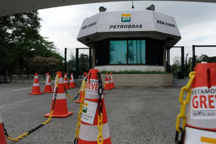 
	Cerca de 30 pessoas se re&uacute;nem em frente &agrave; Refinaria Duque de Caxias em apoio &agrave; greve dos petroleiros: o ministro admitiu que h&aacute; risco de viol&ecirc;ncia em protestos programados para o dia do leil&atilde;o
 (Tânia Rêgo/Agência Brasil)