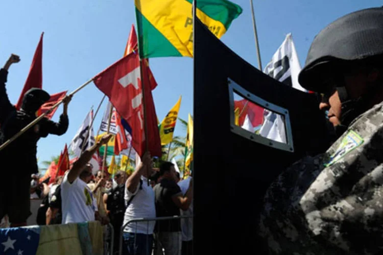 
	Dezenas de manifestantes se re&uacute;nem na Barra da Tijuca, para protestar contra a licita&ccedil;&atilde;o do pr&eacute;-sal: a For&ccedil;a Nacional de Seguran&ccedil;a revidou com bombas de efeito moral e spray de pimenta
 (Tânia Rêgo/Agência Brasil)