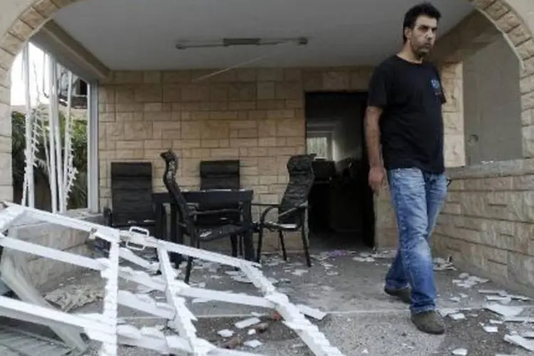 Um homem verifica os danos causados a uma casa atingida por um foguete lançado da Faixa de Gaza (David Buimovitch/AFP)