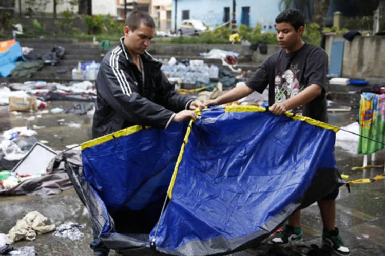 Homens tentam reerguer acampamento: centenas de policiais da GNB fortemente armados tomaram quatro acampamentos (Carlos Garcia Rawlins/Reuters)