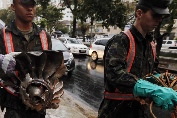 
	Membros da For&ccedil;a A&eacute;rea carregam partes do jato que levava Eduardo Campos, em Santos
 (Paulo Whitaker/Reuters)