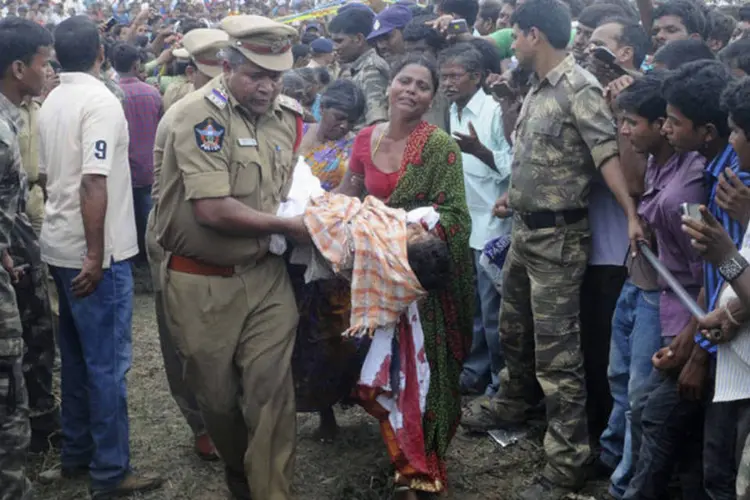 Mulher carrega corpo de criança após colisão: 12 das crianças no ônibus morreram na hora (Stringer/Reuters)