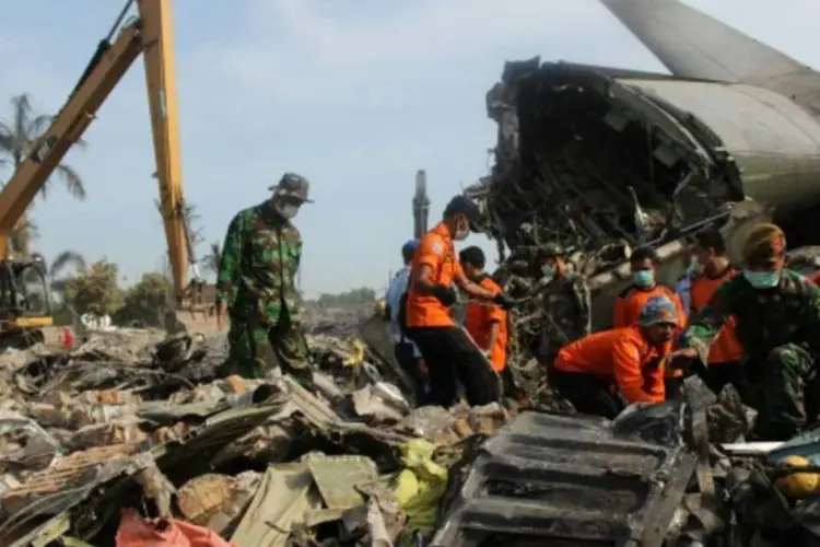 Soldados e bombeiros procuram corpos na área do acidente com avião militar em Medan, ao norte da província de Sumatra (Atar/AFP)